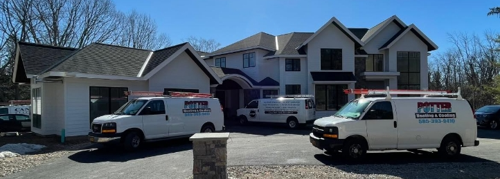 HVAC service vans parked outside a large residential home for heating and cooling installation or maintenance.